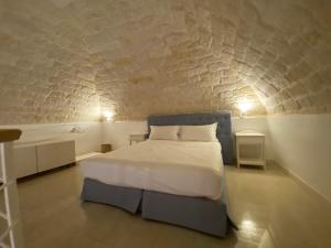 - une chambre avec un lit blanc et un mur en briques dans l'établissement A Casa del Console apartment, à Manfredonia