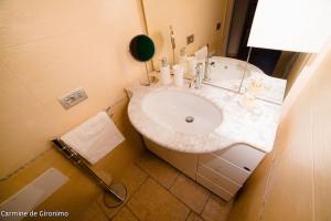 a bathroom with a white sink and a mirror at Seconda stella a destra in Taranto