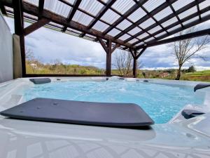 a jacuzzi tub with a pergola at Pixie House - Mrežnica, private pier, hot tub in Gornji Zvečaj