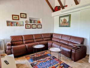 - un canapé en cuir brun dans un salon avec deux tables dans l'établissement Pixie House - Mrežnica, private pier, hot tub, à Gornji Zvečaj