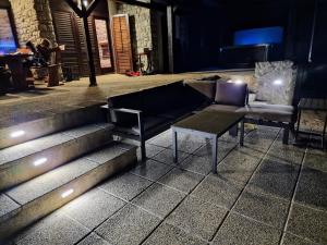 - un canapé et une table sur quelques marches la nuit dans l'établissement Pixie House - Mrežnica, private pier, hot tub, à Gornji Zvečaj