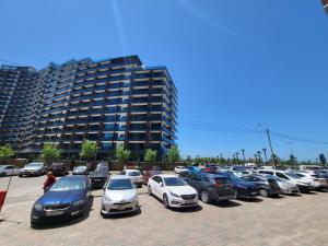 a parking lot full of cars in front of a large building at Black Sea Star in Batumi