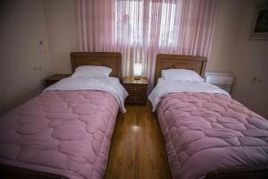 - 2 lits installés l'un à côté de l'autre dans une chambre dans l'établissement Vila Visi Hotel, à Korçë