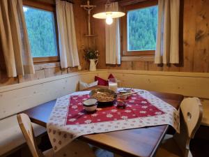 a dining room table with a red and white table cloth at Bergchalet Englhof in Moso