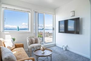uma sala de estar com um sofá e uma televisão em Waterfront Bliss, 2 BR Apt near Alki Beach em Seattle