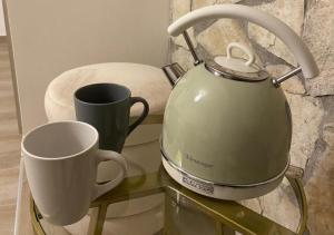 a tea kettle and a cup on a glass table at Da Minguccio in Venosa