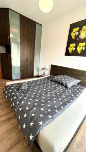 a bedroom with a black and white comforter on a bed at Warszawa Bemowo Pokoje in Warsaw