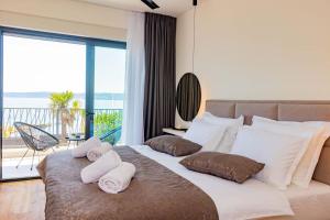 ein Schlafzimmer mit großem Bett und Blick auf das Meer in der Unterkunft Beachfront Villa Sol&Mar with heated pool and jacuzzi in Kaštela + 65 Fotos