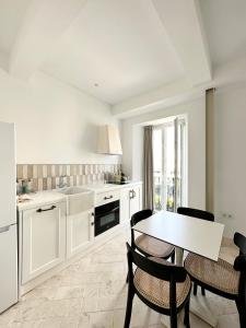 kuchnia z białymi szafkami, stołem i krzesłami w obiekcie Apartamento dúplex con piscina privada en terraza w mieście Alcalá de Guadaira
