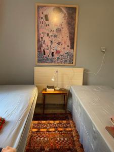 een kamer met 2 bedden en een tafel met een lamp bij להרגיש בבית in Ramat Shlomo