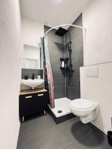 uma casa de banho com um WC, um chuveiro e um lavatório. em Wunderschöne City-Wohnung mit Gartennutzung Nähe Krefeld HBF em Krefeld