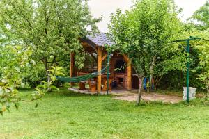 a log cabin with a hammock in the yard at Guest house Al Meri in Travnik