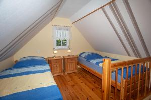 two twin beds in a attic bedroom with a window at Ferienhaus Boddenhus in Middelhagen