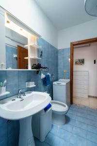 uma casa de banho azul com um lavatório e um WC em VistaMare Paradiso em Torre Vado