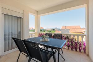 einen Tisch und Stühle auf einem Balkon mit Aussicht in der Unterkunft Apartments Rusula Zadar in Zadar