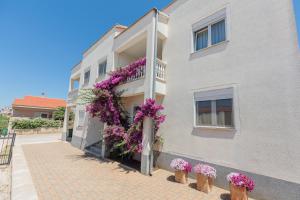 ein Gebäude mit lila Blumen auf der Seite in der Unterkunft Apartments Rusula Zadar in Zadar