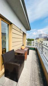 a patio with a wooden table and chairs on a balcony at Warszawa Bemowo Pokoje in Warsaw