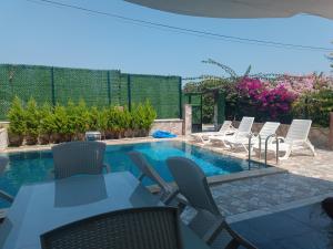 patio z krzesłami i basenem w obiekcie Begonville Villas Ladies Beach w mieście Kusadası