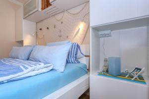 Schlafzimmer mit einem Bett mit blauer Bettwäsche in der Unterkunft Zaton beach Appartement 3 modern und stilvoll eingerichtet in Strandnähe in Zaton