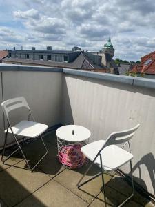 two chairs and a table on a balcony at Schöne, helle Wohnung im Zentrum in Münster