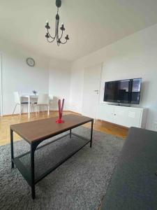 a living room with a table and a tv at Schöne, helle Wohnung im Zentrum in Münster