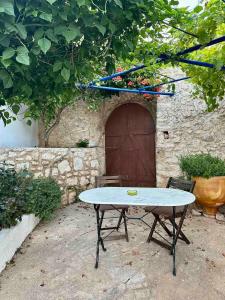 a table in front of a stone building with a door at The Old barrel houses in Kythira