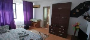 a living room with a dresser and a bedroom at Apartament Nina in Mangalia