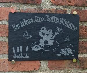 um sinal numa parede de tijolos que diz que não há marmite aux petits deleites em La mare aux petits diables em Équemauville