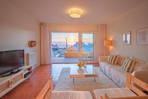 sala de estar con sofá y TV en Portugal Active Moledo Beach House, en Moledo