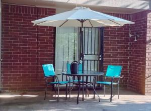 een tafel en stoelen onder een witte parasol bij ZEN'S Retreat in North Little Rock