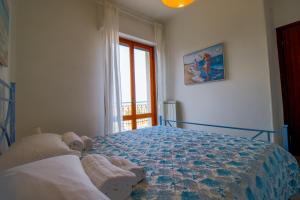 a bedroom with a large bed with a window at La terrazza - By Ligooria in Pietra Ligure