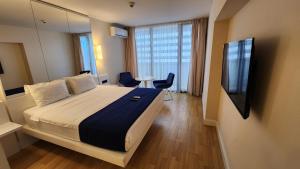 um quarto de hotel com uma cama e uma televisão em Sea Breeze Studio, Orbi City, block A em Batumi