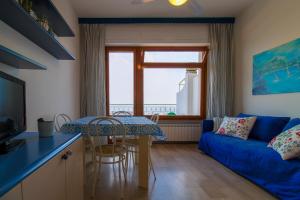 een woonkamer met een blauwe bank en een tafel bij La terrazza - By Ligooria in Pietra Ligure
