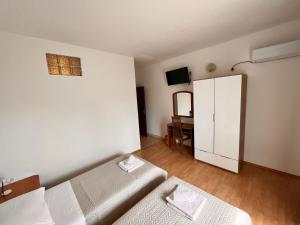 a small bedroom with two beds and a cabinet at Pansion TONY PAG in Pag