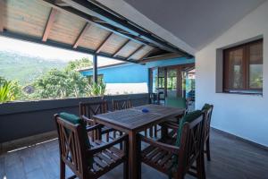 comedor con mesa y sillas en el balcón en Villa Lino, en Dugopolje