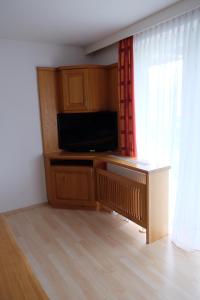 a living room with a flat screen tv next to a window at Putz Appartements in Gröbming