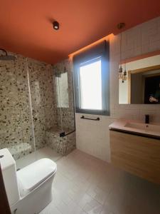 uma casa de banho com um WC, um chuveiro e um lavatório. em Ático en Llanes con terraza junto Paseo San Pedro em Llanes