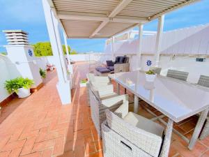 a patio with a table and chairs on a brick floor at Penthouse with 95m2 Solarium, pool and seaview in Comarruga