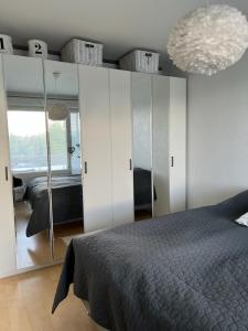 ein Schlafzimmer mit einem Bett und einem großen Spiegel in der Unterkunft kauppalankatu kolmio in Kouvola