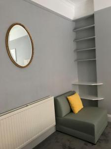 a living room with a green couch and a mirror at Grange Lone entire apartment with two double beds in Edinburgh