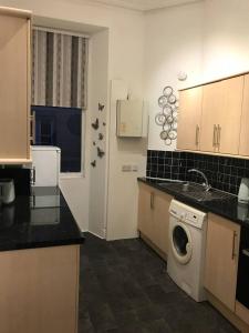 a kitchen with a sink and a washing machine at Grange Lone entire apartment with two double beds in Edinburgh