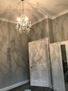 a room with a chandelier and a white door at Grange Lone entire apartment with two double beds in Edinburgh