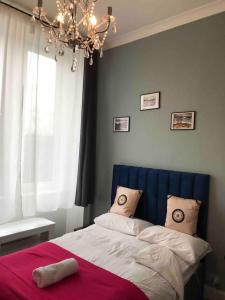 Schlafzimmer mit einem Bett mit blauem Kopfteil und einem Fenster in der Unterkunft Grange Lone entire apartment with two double beds in Edinburgh