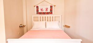 a small bedroom with a bed with a white headboard at Kyano seaview in Olympos