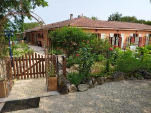 un jardin avec une porte en bois en face d'une maison dans l'établissement Le Mas de Balmes, à Vers
