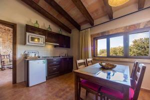 a kitchen with a table and a white refrigerator at Finca Cas Contador Mallorca in Algaida