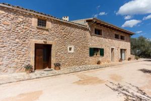 een groot stenen gebouw met een deur ervoor bij Finca Cas Contador Mallorca in Algaida