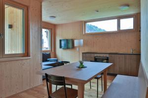 a kitchen and living room with a table and chairs at Bergreich Appartement 1 in Schoppernau