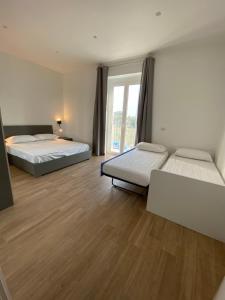 a room with two beds and a window at G’S HOME in Margherita di Savoia