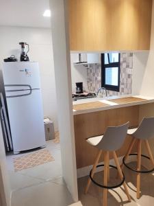 uma cozinha com um frigorífico branco e 2 cadeiras em Apartamento novíssimo Copacabana no Rio de Janeiro
